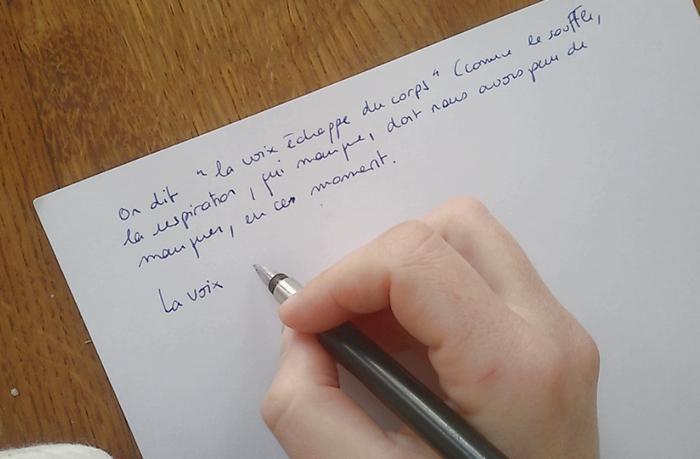 Une main avec un stylo plume, inscrivant des mots sur une feuille, vidéo d'Eline Aroch et Coraline Grandin